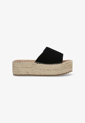 Sandalia de cuña de ante negro con una suela de plataforma de yute, que presenta un diseño de tiras cruzadas y costura texturizada a lo largo del borde.