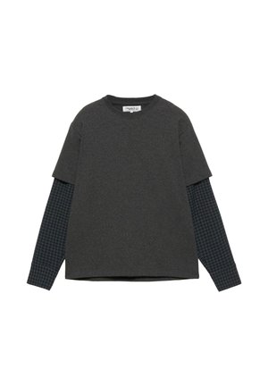 T-shirt gris à manches courtes superposé à une chemise à manches longues à carreaux. Mélange de coton, coupe décontractée, avec un col rond et des motifs contrastants sur les manches.
