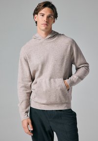 Hellgrauer Strickpullover mit Kängurutasche, langen Ärmeln und einer lässigen Passform. Der Stoff hat ein weiches, strukturiertes Aussehen.