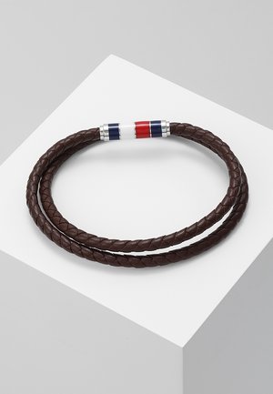 Bracelet en cuir tressé marron double-tour avec une fermeture magnétique présentant des rayures verticales bleues, blanches et rouges.