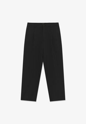 Čierne nohavice s rovnakým strihom, so zapínaním na gombík, dvoma prednými vreckami a hladkou textúrou látky. Strihaný dizajn s záhybmi.