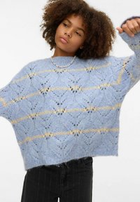 Gaiši zils adīts džemperis ar reljefu rakstu un dzeltenām svītrām krūšu daļā. Brīvs piegriezums, ribota apkakle un aproces.