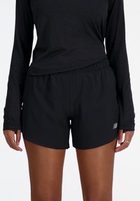 Svarta träningsshorts med resårmidja, lätt material och en logotypdetalj. Matchas med en långärmad svart topp.