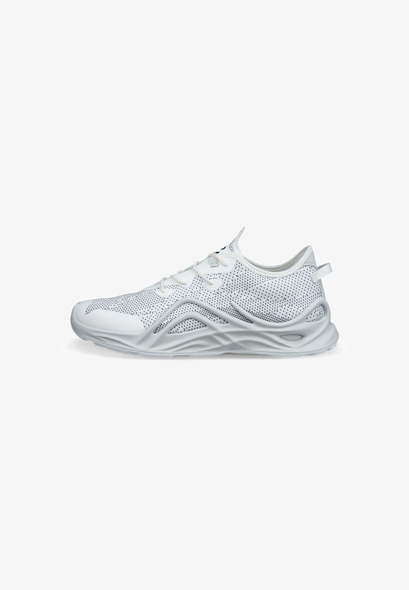 White athletic shoe featuring a mesh upper with dotted pattern, padded collar, and a textured rubber sole with curvy design elements.