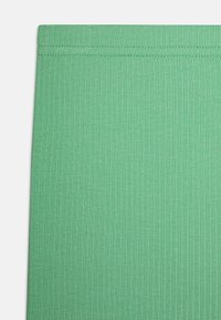 Tissu vert côtelé avec une texture lisse et une ceinture élastique. Le design présente des rayures verticales sur l'ensemble du matériau.