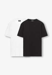 Δύο απλά T-shirts με στρογγυλή λαιμόκοψη, ένα μαύρο μπροστά και ένα λευκό πίσω, απλωμένα πάνω σε λευκό φόντο.