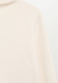Jasno beżowy sweter z golfem o miękkiej dzianinie, z długimi rękawami i luźnym krojem, minimalne szwy, brak widocznych elementów metalowych.