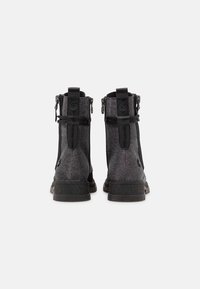 Czarne botki za kostkę z fakturowanym materiałem, bocznymi zamkami błyskawicznymi i mocnymi gumowymi podeszwami. Posiadają pętelkowy akcent z tyłu, ułatwiający zakładanie.