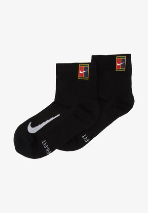 Meias de crew pretas feitas de um tecido com textura canelada. Apresenta um logótipo da Nike em branco e um design em blocos de cor no tornozelo.