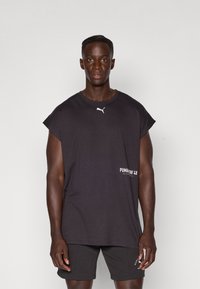 Black cotton sleeveless t-shirt featuring a white Puma logo on the chest and graphic text "PUMAW 28" on the side. Casual fit and crew neck.