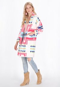Kleurige, gepatternde cardigan met roze, blauwe en groene ontwerpen. Gemaakt van zacht materiaal met een open voorkant en twee zijzakken.