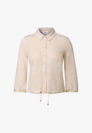 Blusa button-up color crema con colletto, maniche a tre quarti, orlo con cordoncino e tessuto a maglia testurizzata. Presenta sette bottoni.