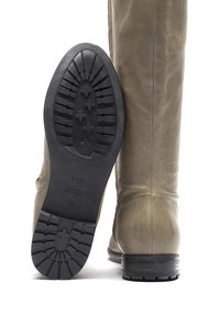 Stivali al ginocchio in pelle beige con finitura strutturata, dotati di suola in gomma nera con battistrada e cuciture sottili lungo le cuciture.