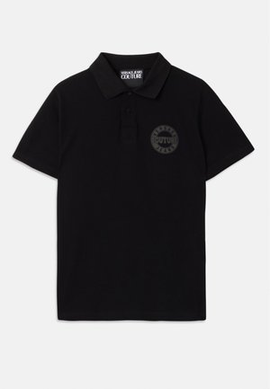 Camiseta polo negra de algodón, con una tapeta de tres botones, mangas cortas y un logotipo redondo texturizado en el lado izquierdo del pecho.