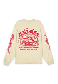 Beige blouse met lange mouwen, voorzien van een rode grafische print op de achterkant en mouwen, met vetgedrukte tekst en patronen, gemaakt van zachte katoen.
