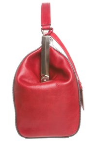 Punainen nahkalaukku, jolla on pyöreä muoto, metallinen kahva ja löysä yläosa. Ominaisuuksiin kuuluu litteä pohja, sileä pinta ja kontrastina musta reuna.