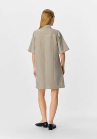 Gestreepte jurk met korte mouwen en een kraag, gemaakt van lichtgewicht stof in beige en donkerbruin. Heeft een rechte silhouet en een knie-lange zoom.