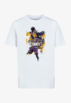Camiseta blanca de algodón con un colorido estampado gráfico de un jugador de baloncesto, con el texto "CADA DISPARO CUENTA" en acentos negros y amarillos.