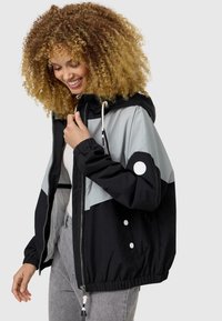Color-blocked hooded jacket featuring black and light gray panels, elastic cuffs, a drawstring hood, and a zip closure with button accents.