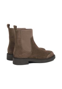 Brązowe zamszowe botki za kostkę z prążkowanymi elastycznymi panelami po bokach, pętelkami z tyłu i czarną gumową podeszwą, pokazane z boku na białym tle.