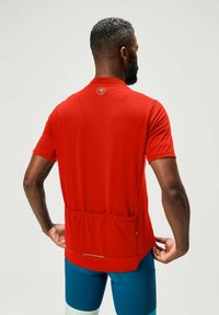 Rotes kurzärmliges Sportshirt aus atmungsaktivem Stoff, mit einer Rückentasche und reflektierendem Akzent am unteren Saum.