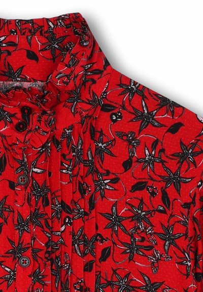 Rode blouse met een bloemenpatroon met zwarte bloemen en bladeren. Gerimpelde kraag, knoopsluitingen en plooien zorgen voor textuur.