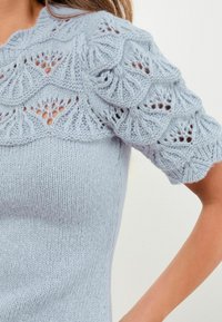 Jasnoniebieski sweter z dzianiny z krótkimi, teksturowanymi puff rękawami, z falistym wzorem z koronki. Gładki korpus z dopasowanym krojem.