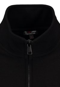 Chaqueta de forro polar negra con un cuello alto, cremallera frontal y un acabado texturizado. Etiqueta visible en el interior del cuello con detalles de la marca y la talla.