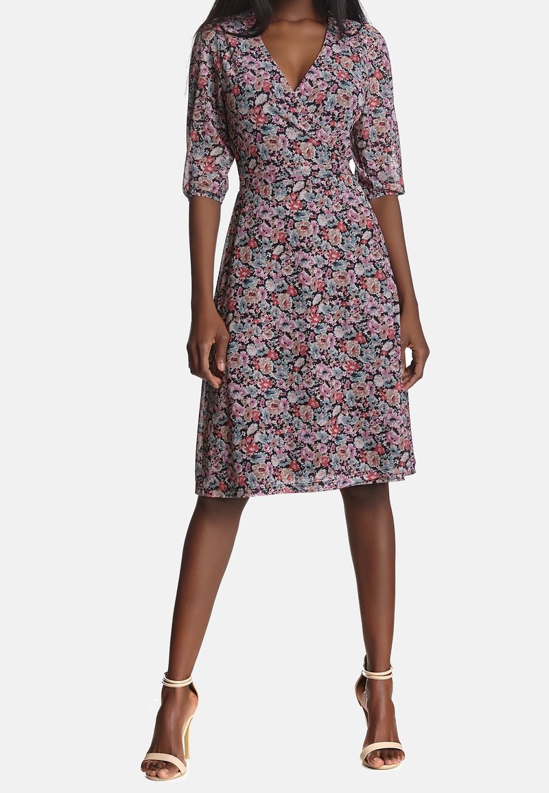 Květinové zavinovací šaty v černé barvě, s tříčtvrtečními rukávy, výstřihem do V a přiléhavým pasem, s ministřihnuto ke kolenům.