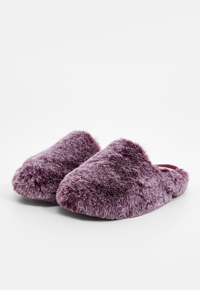 Lila, flauschige Hausschuhe mit einer weichen, plüschigen Textur, zum Hineinschlüpfen, und abgerundeten Kanten für Komfort und Wärme. Keine sichtbaren Beschläge.