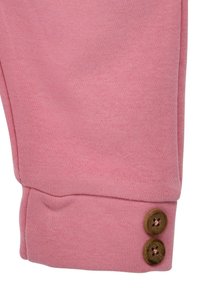 Rosa Baumwollhosen mit glatter Textur, ausgestattet mit einem umgeschlagenen Saum und zwei Holzknöpfen am Bündchen zur Befestigung.
