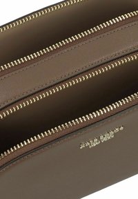 Portafoglio in pelle marrone con tre scomparti con zip, dotato di hardware della zip in tonalità oro e una finitura liscia e strutturata.