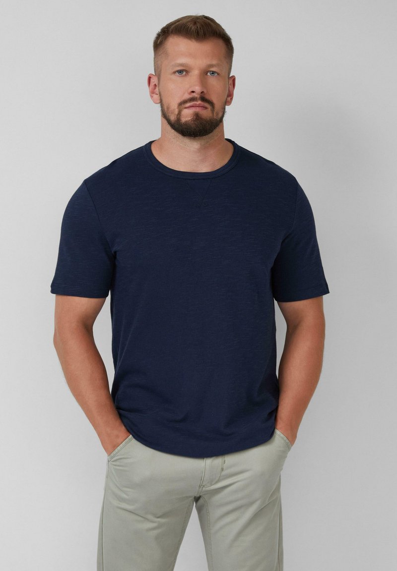 Marineblauwe t-shirt met korte mouwen en ronde hals, gemaakt van gestructureerde stof. Casual pasvorm met subtiele stiksels op de schouders.