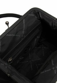 Mustankankainen käsilaukku, jonka sisäpuolella on vetoketjullinen tasku ja brändätty vuori. Varustettu ylhäällä oleva kehys ja lukko, sekä sileä pinta.