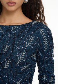 Marineblaues, verziertes Kleid mit aufwendiger Perlenstickerei und Pailletten in Blattmustern, rundem Ausschnitt und langen Ärmeln.