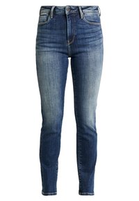 Tmavě modré úzké džíny s vybledlým přechodem, vysokým pasem, klasickým šitím a zapínáním na knoflíky. Mají přední i zadní kapsy.