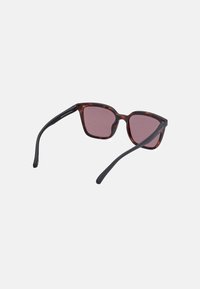 Ochelari de soare tortoise brown cu lentile roz, formă pătrată și brațe negre. Prezintă un design minimalist cu branding subtil.