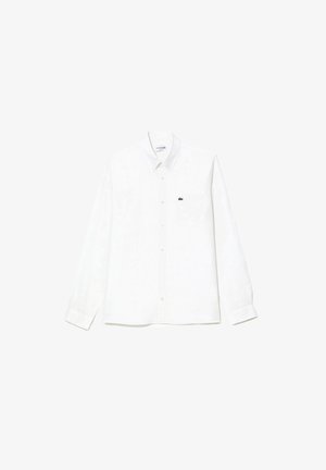 Camisa de manga larga blanca de lino, con cuello button-down, un bolsillo en el pecho y un pequeño logo de cocodrilo verde en el lado izquierdo del pecho.