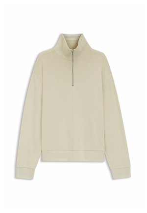 Light beige long-sleeve pullover with a ribbed texture, high collar, and a silver quarter-zipper front closure.