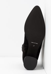 Semelle de chaussure noire à bout pointu avec une surface antidérapante texturée, taille 37, avec l'inscription « Made in Portugal ».