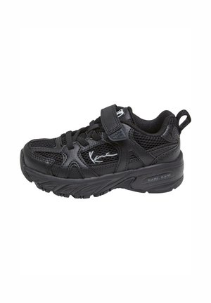 Svart sneaker med mesh og syntetisk overdrap, snøring og borrelås, polstret krage, teksturert såle og logo-detalj på siden.