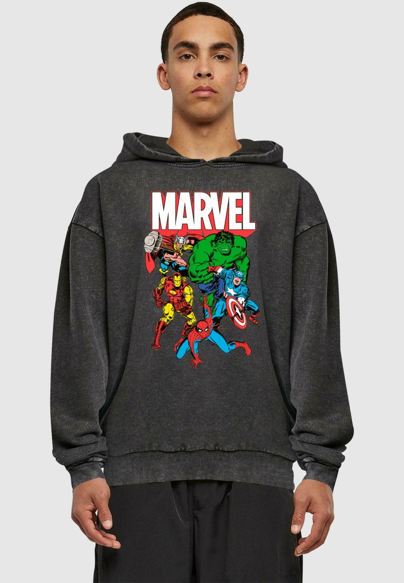 Siva dukserica napravljena od mekanog materijala sadrži šareni grafički prikaz Marvelovih superheroja, uključujući Hulka, Iron Mana i Spider-Mana.