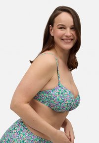 Top de bikini multicolor con un estampado floral en verde, morado y rosa, con tirantes ajustables y un diseño fruncido.