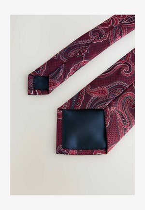 Red paisley tie with intricate patterns and contrasting navy lining. Smooth texture, pointed tips, and rectangular design at the base.