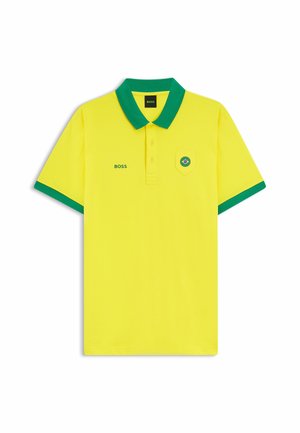 Gul polo-shirt med grøn krave og ærmekanter, "BOSS"-logo på brystet og et lille brasiliansk flag på lommen.