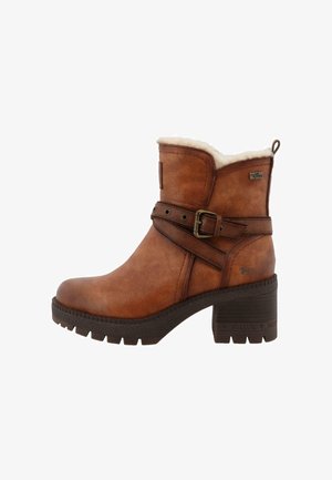 Bottines en cuir marron avec un fini texturé, doublure en fausse fourrure et une sangle décorative fermée par une boucle en métal. Talon épais.