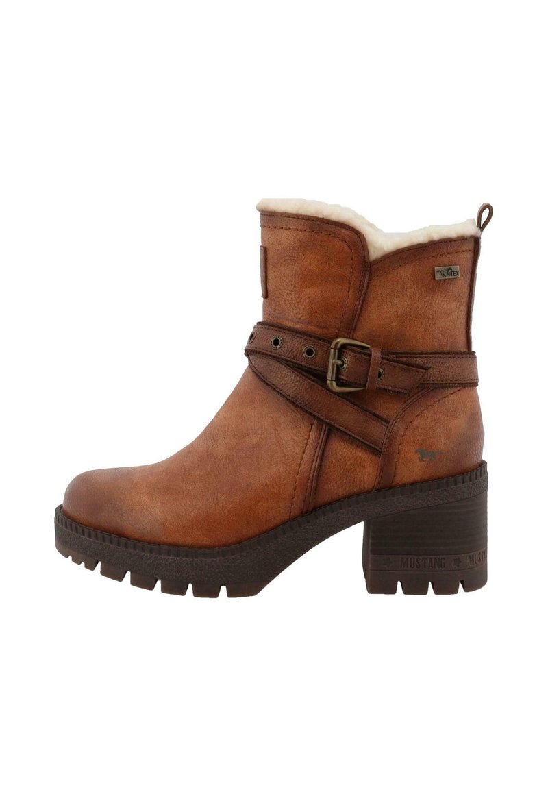 Bottines en cuir marron avec un fini texturé, doublure en fausse fourrure et une sangle décorative fermée par une boucle en métal. Talon épais.
