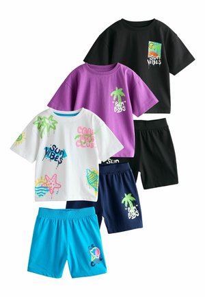 Tre farverige børneoutfits med grafiske t-shirts og matchende shorts, med motiv af palmer, sol, søstjerner og tekst som "Sun Vibes" og "Palm Boys."