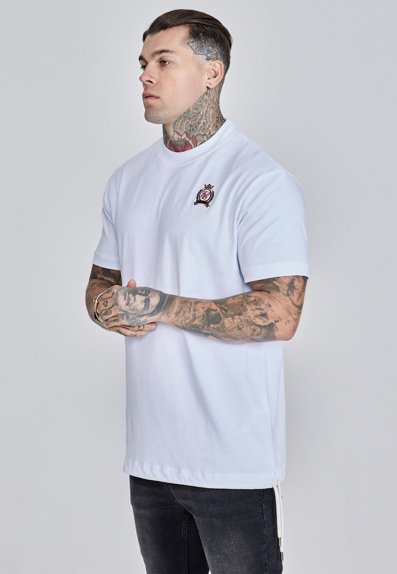 Bijela majica kratkih rukava od pamuka s okruglim izrezom, s vezenim logotipom na prsima i ravnim rubom.