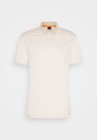 Polo beige à manches courtes avec patte à deux boutons, bordure blanche au col, et petit logo embossé sur la poitrine gauche.